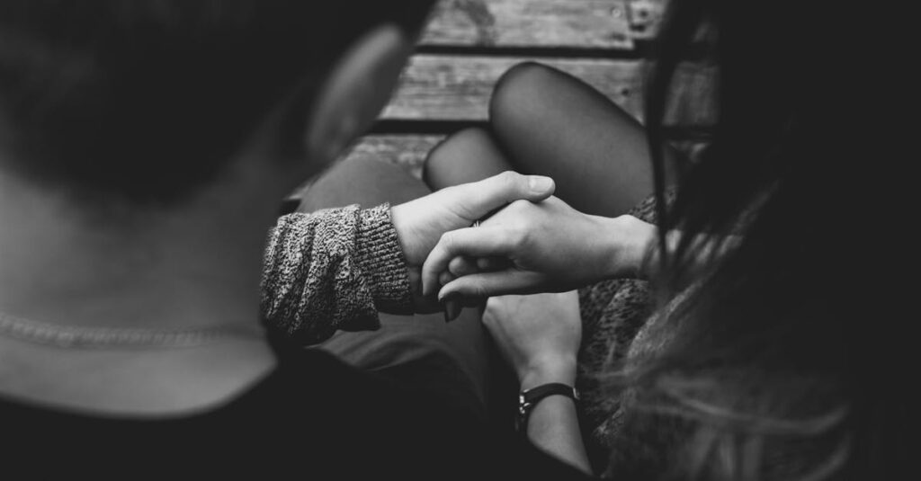 A romantic black and white image of a couple holding hands, symbolizing love and connection.