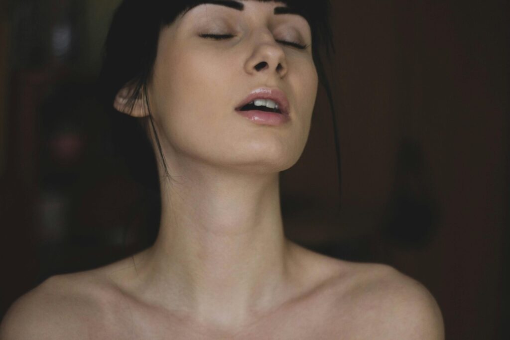 Close-up of a serene young woman with eyes closed, enjoying a moment of tranquility indoors.
